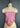 The vintage-style "My Favorite Bandana in Pink 66" neckerchief is elegantly draped from At Home With Ray, showcased in a dark setting.