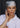 Woman wearing a silk head scarf in pale grey with dark blue illustrations and bright red trim