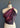 A deep plum paisley silk scarf styled as a draped one-shoulder top on a dress form, secured with a fuchsia raffia strap and coconut wood ring.