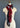 The "Guardian in Madder Root" scarf from At Home With Ray is featured, showcasing a blend of patterns such as black and white polka dots, black and white stripes, and various red and black geometric designs. Made from a luxurious cashmere silk blend, this scarf is elegantly tied in a loose knot at the front.