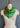 A vibrant green Beginnings 68 silk bandana with a leaf and butterfly design, draped elegantly over an aged dressmaker's mannequin against a gray wall.